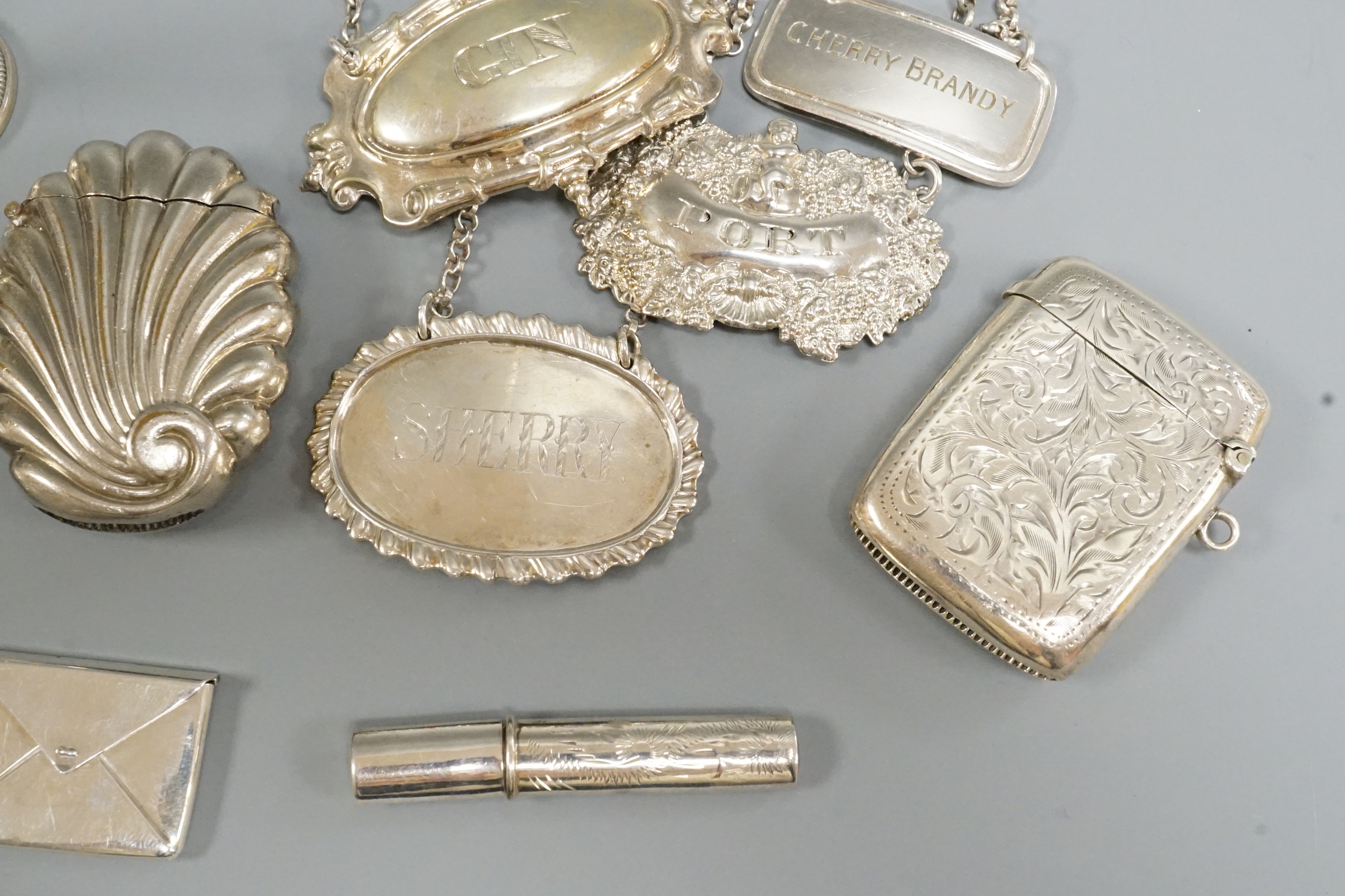 Two silver wine labels including 19th century, silver vesta case, silver cheroot holder, silver lyre menu holder and other items.